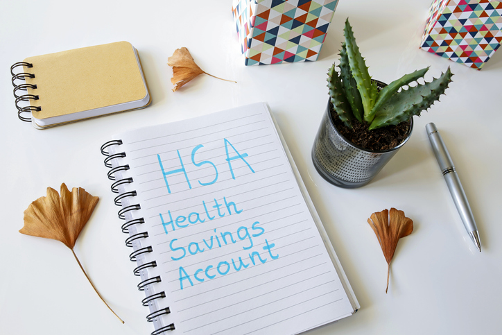 HSA health savings account written in a notebook on white table