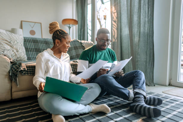 Couple sitting on ground looking over options on paper.