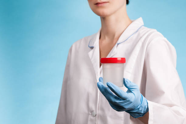 Medical professional holding drug testing container