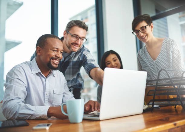 Co-workers looking at computer and smiling