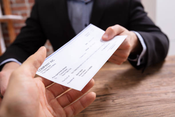 Two business people exchanging pay check