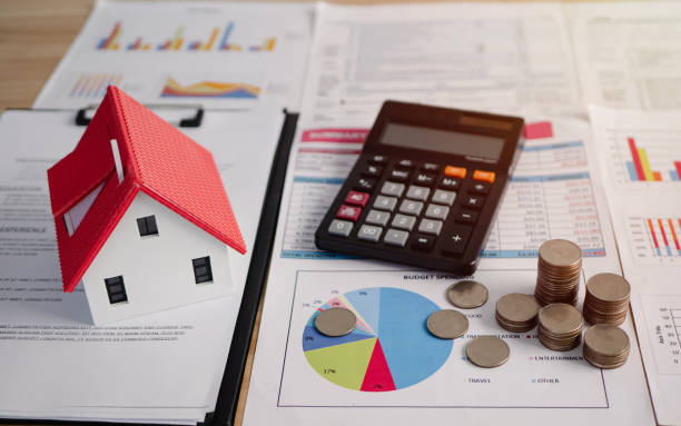 House, money and calculator on top of paper