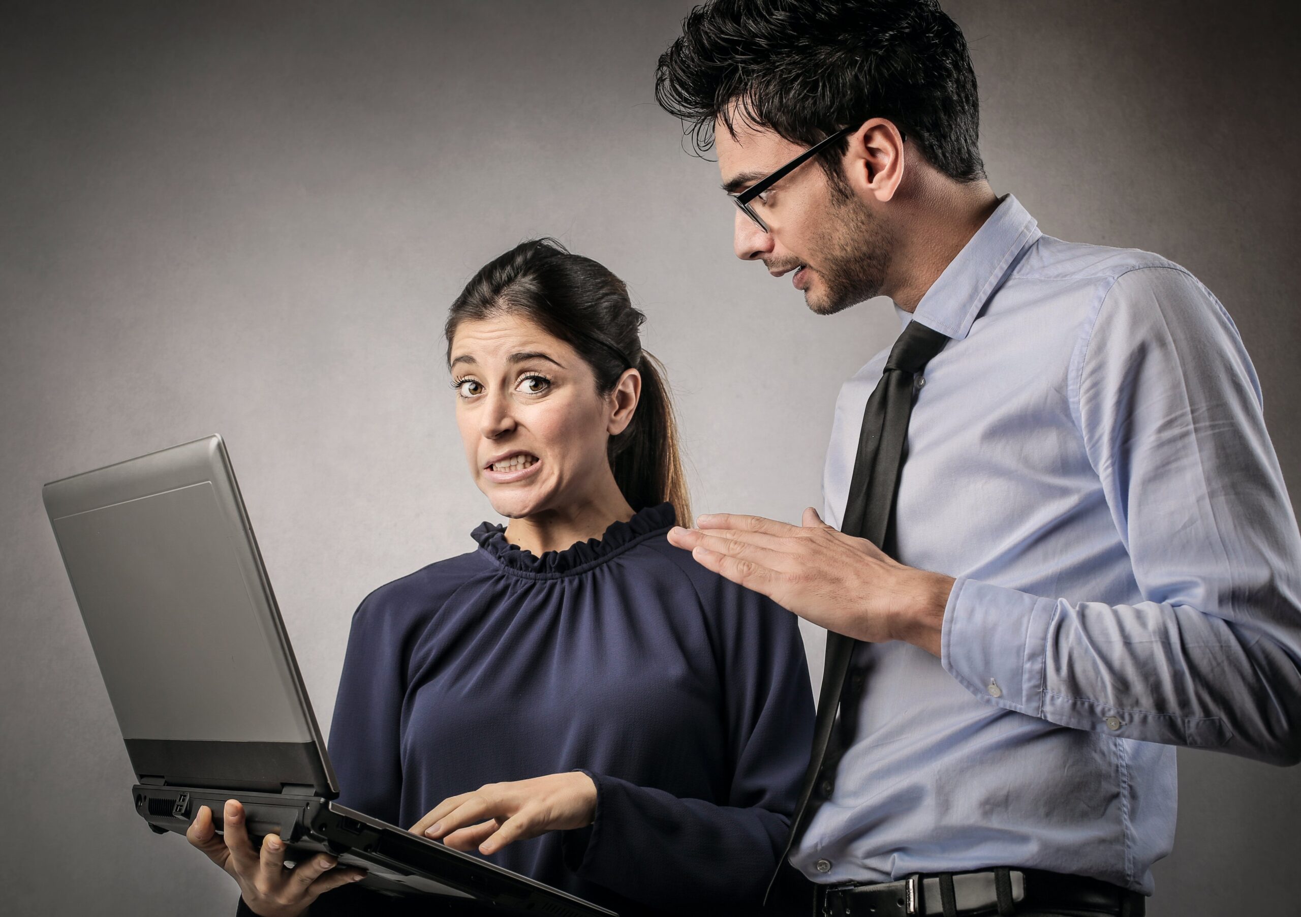 Employee and employer looking at computer making a face.