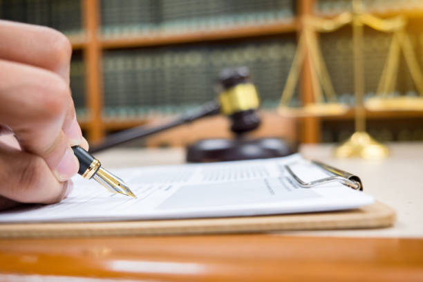 Lawyer sitting at his desk, studying new laws and legislation and taking notes.