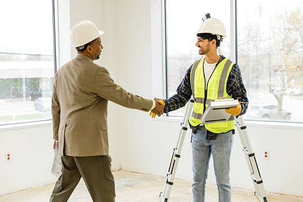 construction worker and business man shake hands.