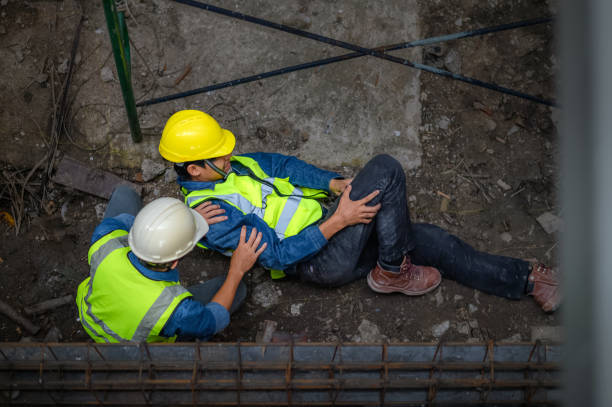 A young Asian builder falls from a scaffold at a construction site. An engineer supervising the construction came to the aid of a construction worker who fell from a height with hip and leg injuries.